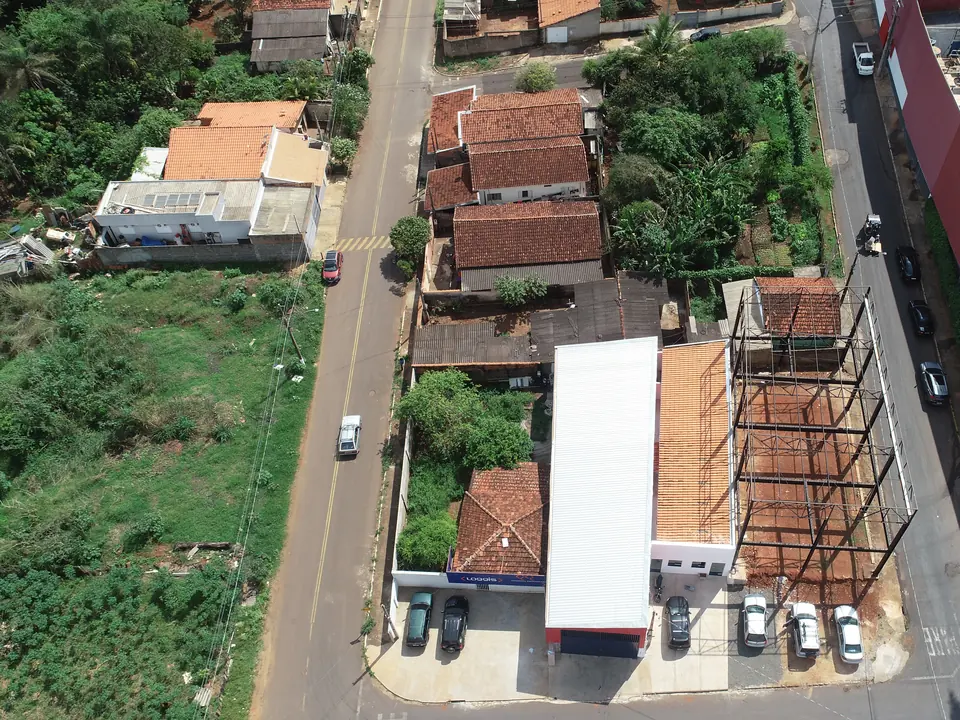 Vista aérea, de drone, de um lote com construção metálica e imóveis vizinhos